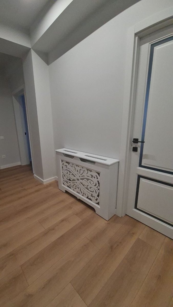 Mască ornamentală albă, lângă o ușă
