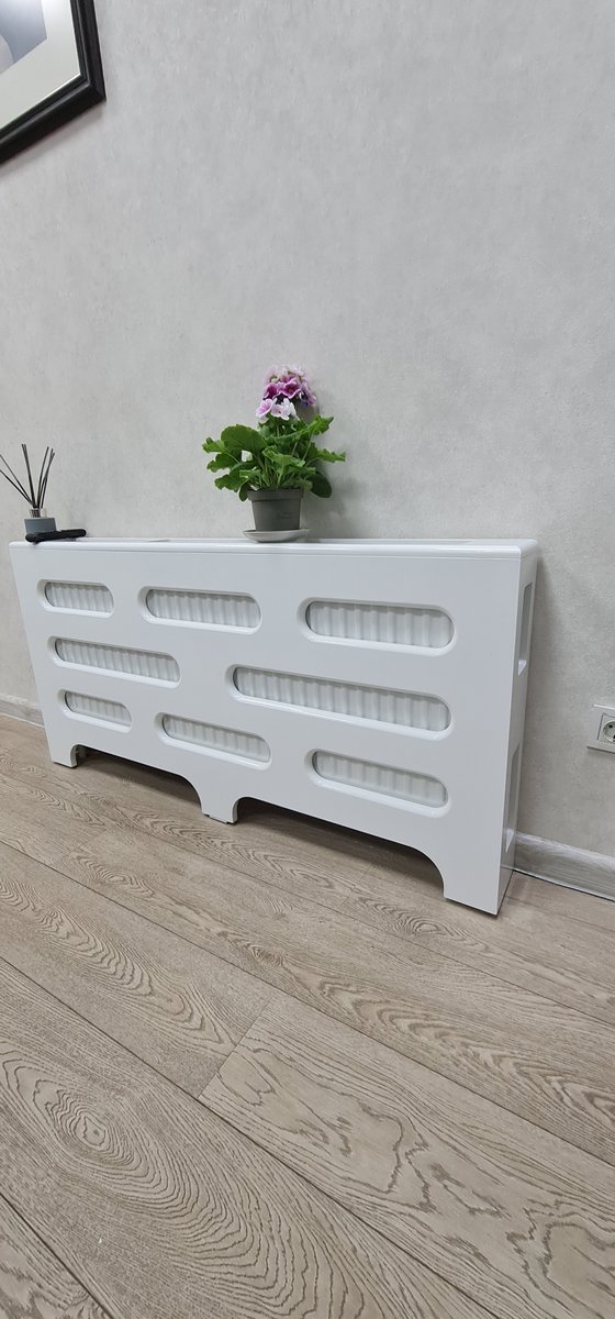 Mască albă cu o plantă deasupra, lângă fereastră